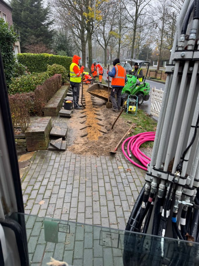 Bauarbeiter in leuchtenden Westen graben den Weg für ein Projekt.